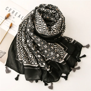 Close-up of geometric diamond pattern scarf with fringe and soft linen texture