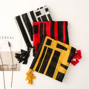 Detail of color-block scarves with fringe tassels and woven geometric patterns