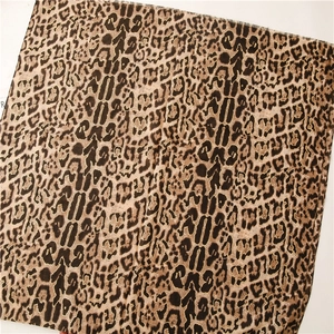 Close-up of golden leopard print scarf showing detailed fabric texture and patterns