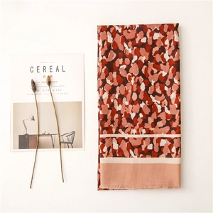 Détail de l'écharpe orange chaud à imprimé léopard avec une texture douce et franges