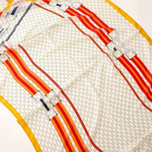 Macro shot of silk scarf detailing interlocking motifs with horsebit and chain prints