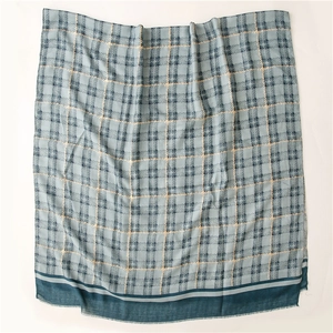 Detail view of cotton-linen scarf with gold foil grid pattern and blue fringe edges