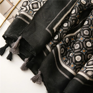 Detailed close-up of geometric pattern scarf with herringbone weave and fringe tassels