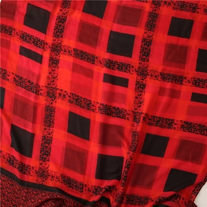 Gros plan sur un tissu doux à carreaux rouges et noirs avec des textures géométriques