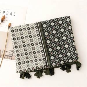 Close-up of geometric pattern cotton scarf with decorative dark green fringe detail