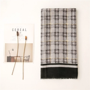 Detail of plaid scarf featuring gray and black check patterns with subtle yellow accents
