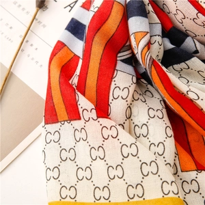 Detail of colorful long cotton linen scarf featuring classic monogram patterns and soft texture
