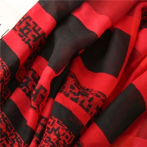 Gros plan sur le tissu à carreaux rouge et noir de l'écharpe avec texture fine et franges