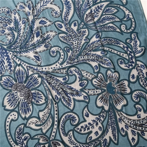Detail eines bedruckten Schals mit blauen Blumenmustern und Fischgräten-Webstruktur