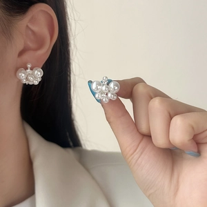 Elegant white cluster pearl earrings with cubic zirconia accents on a female model