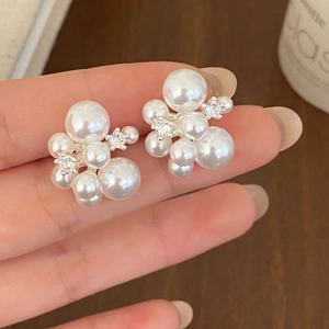 Macro shot of elegant cluster pearl stud earrings with sparkling cubic zirconia accents