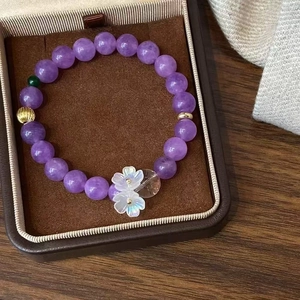 Vue détaillée du bracelet en perles de cristal violet avec pendentifs de coquillages