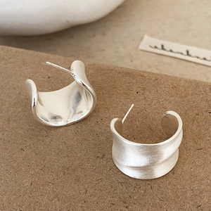 Minimalist silver brushed C-shaped hoop earrings with a textured matte metallic finish
