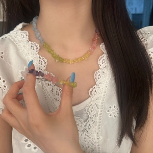 Colorful natural crushed stone necklace and bracelet set shown on model in white lace