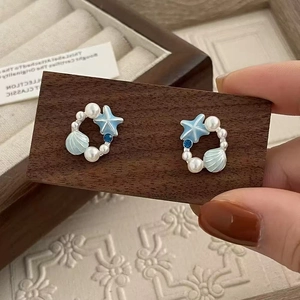Boucles d'oreilles étoiles de mer et coquillages bleus avec perles sur bois rustique