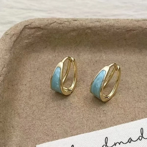 Élégantes boucles d'oreilles rondes dorées avec finition émail marbré bleu clair pour femme