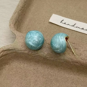Boucles d'oreilles sphériques bleues marbrées avec tige dorée sur étiquette artisanale