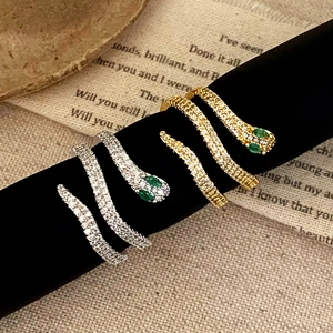 Snake open rings in gold and silver finish with white zircon and green gemstone eyes