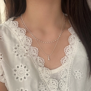 Minimalist double-layered silver waterdrop pendant necklace worn on white lace top