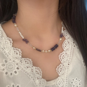 Elegant freshwater pearl and purple crystal beaded necklace worn by a female model