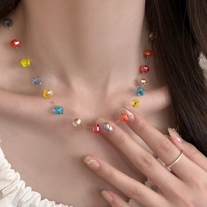 Close-up of colorful rainbow pumpkin bead necklace worn by a model on collarbone