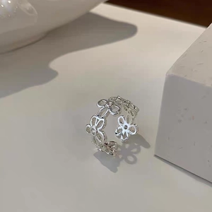 Macro di anello aperto argento con fiori traforati e pietre di zircone lucenti