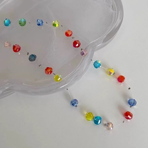 Macro shot of colorful faceted crystal beads on a pumpkin-style summer beach necklace