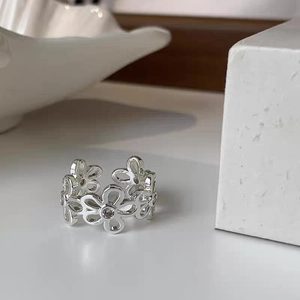 Dettaglio dell'anello a margherita traforato con zirconi e fascia regolabile argento