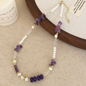 Detail of beaded necklace with purple crystal stones, pearls and adjustable gold clasp