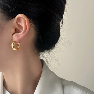 Minimalist thick gold hoop earrings for women, classic geometric design on model ear