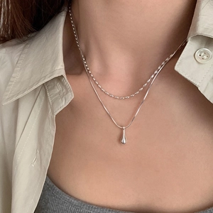 Minimalist double layer silver drop necklace set styled on a model in chic attire