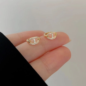 French style gold pig nose hoop earrings with micro-inlaid zircons shown on hand