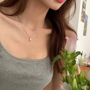 Detail of silver double layer necklace featuring teardrop pendant on model