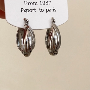 Detail shot of silver multi-layered twisted hoop earrings with a sleek metallic finish