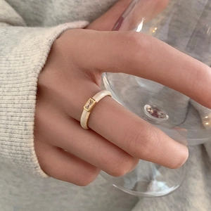 Detailed view of a cream enamel ring featuring a rectangular zircon on a golden setting