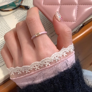 Detail of pink enamel ring with rectangular zircon gemstone on a soft lifestyle background