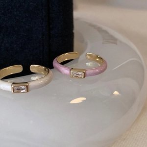 Macro view of adjustable enamel open rings with rectangle cubic zirconia on a ceramic tray