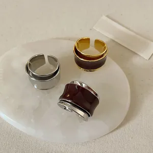 Makroaufnahme französischer Vintage-Ringe mit bordeauxrotem Lack auf weißem Marmorteller