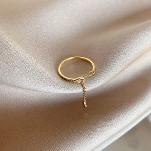 Detail of adjustable star charm ring with zircon pavé setting on champagne silk fabric