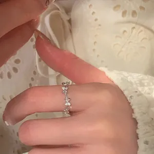 Close-up of elegant butterfly ring with micro-pave zircons worn on hand over soft lace