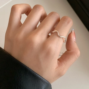 Minimalist silver wavy curve ring for women shown on hand with elegant styling