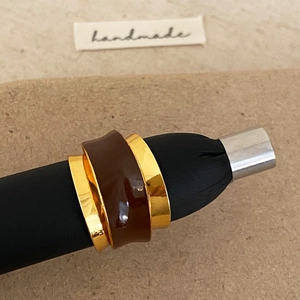 Macro detail of French vintage irregular double-layer ring with brown enamel and gold plating
