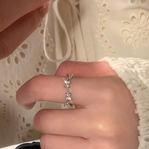 Close-up of elegant silver butterfly ring with cubic zirconia stones worn on finger