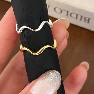 Set of two minimalist wavy stackable rings in polished gold and silver finishes