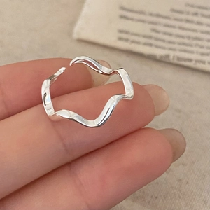 Macro shot of silver wavy irregular open ring with sleek minimalist curved design