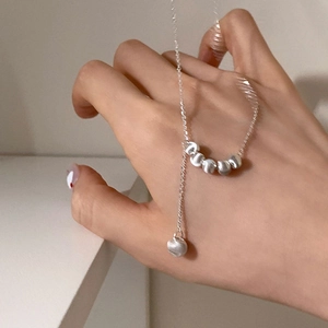 Collier en Y argenté minimaliste avec des perles métalliques mates sur une chaîne
