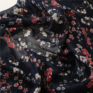 Detail of floral printed scarf fabric showing soft navy blue texture and small flowers
