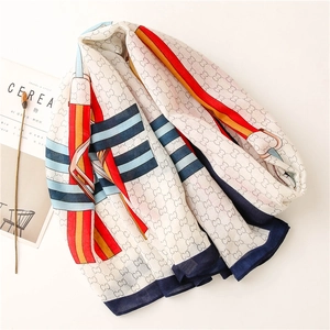 Detail of white cotton linen scarf featuring colorful interlocking chain print and stripes