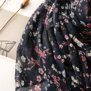 Detailed texture of dark blue floral scarf with soft cotton-linen feel and delicate fringe