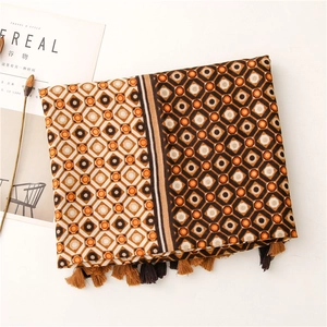 Detailed view of geometric diamond print scarf with fringe tassels in earthy tones